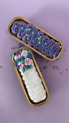 two tins that have some type of cake inside of them with flowers on them