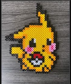 a piece of art made out of perler beads with a pikachu face on it