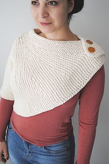 a woman is wearing a sweater with buttons on the front and back, while she has her hands in her pockets