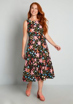 Inspired by vintage spring florals, this black midi dress from Aussie brand Princess Highway features an abundant burst of blooms in shades of pink and blue surrounded by lush greenery, blossoming strawberries, and a variety of cute creatures buzzing throughout. Made from a lightweight cotton weave, this sleeveless dress features a scoop neckline, a semi-fitted bodice, a removable and matching tie-waist belt, and a flowy midi skirt with a deep ruffle hemline.