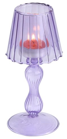 a purple glass table lamp with three lit candles in the bottom and one light on top