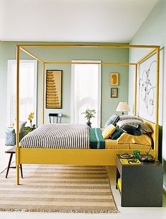 a bedroom with green walls and yellow bed frame