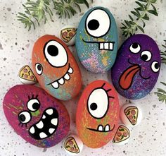 five painted rocks with different faces on them