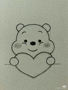 a drawing of a teddy bear holding a heart on a white paper with black outline