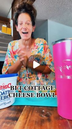 a woman sitting at a table in front of a pink cup with the words diet cottage cheese bowl on it