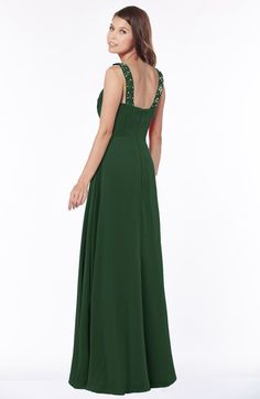 a woman in a long green dress is looking back at the camera with her hand on her hip