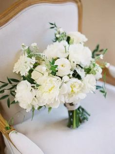 a bouquet of white flowers sitting on top of a chair