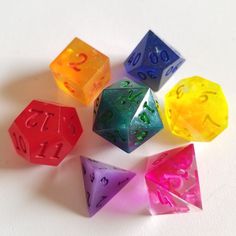 six different colored dices sitting on top of each other with numbers painted on them