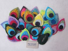 a pile of colorful felt eyeballs sitting on top of a white surface