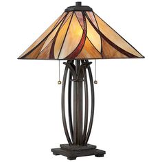 a lamp that is sitting on top of a wooden stand with a glass shade over it