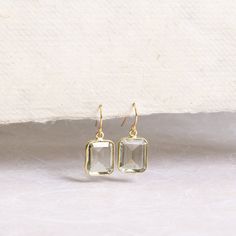 Green Amethyst Emerald Cut Drop Earrings 14k Gold Filled Ear wire - Elegant dangle hook earrings, square cut, bridesmaids or bride jewelry Swooning over these super elegant and chic emerald cut faceted rectangle drop earrings in stunning Green Amethyst. Stone: Genuine Green Amethyst Please note due to nature of our genuine stones no two are alike and the ones you will receive will vary slightly from the ones pictured in the photos. Bezel: Vermeil Gold Ear-wire: 14k Gold Filled Gemstone: 13mm wide x 11mm height About "Gold Filled Jewelry": Also called rolled-gold. These jewelry items are not actually filled with gold. They are made of a base metal covered by sheets of gold in a mechanical bonding process. Effectively a thick coat of gold: the industry standard for the gold content is 5% or Rectangular Gemstone Earrings For Wedding, Rectangular Faceted Jewelry For Weddings, Square Cut Jewelry With Matching Earrings For Gift, Emerald Cut Drop Earrings, Earrings Square, Thick Coat, Bride Jewelry, Square Earrings, Square Cut