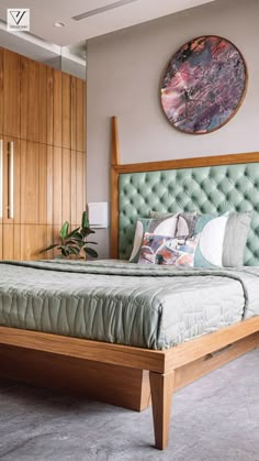 a bedroom with a large bed and wooden paneled walls, along with a painting on the wall