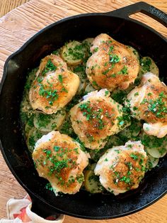 a skillet filled with dumplings covered in parmesan cheese and chives