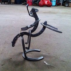 a metal sculpture sitting on top of a cement floor