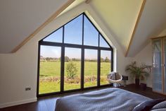 a bedroom with a large window overlooking a field