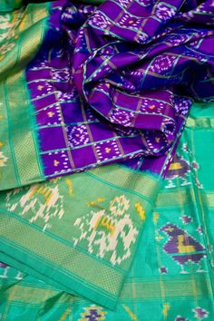 A broad border along with the ikat tye and dye work all over the pallu with an illuminating zari work on the pallu and border in traditional style makes it complementary to each other along with a solid purple and rama green color body. Color: A shade of Purple and rama green color Technique: Amazing work of ikat weaving work on the whole saree with solid body Fabric: Ikat Silk Quality: Indyvogue's Assurance of Pure Silk Mark Certified Saree Navratri Silk Traditional Wear With Ikat Print, Navratri Ikat Print Silk Traditional Wear, Ikat Print Traditional Wear For Weddings And Festivals, Bollywood Style Festive Ikat Print Traditional Wear, Festive Ikat Print Traditional Wear For Wedding, Bollywood Style Festive Traditional Wear With Ikat Print, Festive Bollywood Traditional Wear With Ikat Print, Festive Ikat Print Saree With Traditional Drape, Ikat Print Art Silk Traditional Wear For Weddings