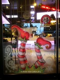 an image of a store window decorated with candy canes and santa hats on it