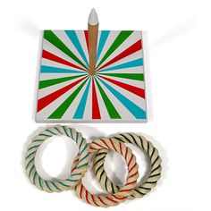 three different colored rope rings next to each other on a white surface with a red, green, and blue striped design