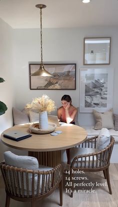 a woman sitting at a round table in a living room