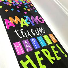 a black door mat with colorful lettering on it that says amazing things happen here,