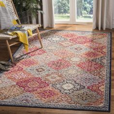 an area rug with various colors and patterns on the floor in front of a window