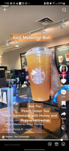 someone is holding up a cup of iced tea in front of a counter with drinks on it