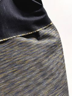 a close up view of the side of a woman's skirt with yellow and blue stripes