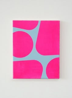 a pink and blue square with circles on it, mounted on a wall in a white room