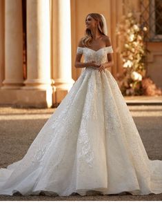 a woman in a wedding dress is standing outside with her hands on her hips and looking off to the side