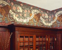 an old library with bookshelves and decorative wallpaper