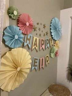 some paper fans are hanging on the wall and there is a happy new year banner