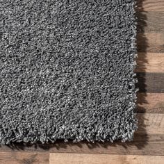 an area rug with wood flooring and grey carpet on the ground, top view