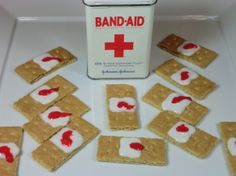 some crackers with white and red toppings next to a box of bandages