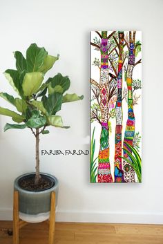 a potted plant sitting next to a painting on the wall in front of a white wall