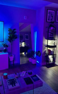 a living room filled with furniture and purple lighting on the walls, along with potted plants