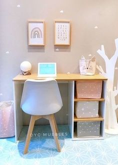 a white desk and chair in front of a wall with tree decals on it