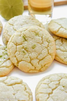 several white cookies with green sprinkles next to a glass of orange juice