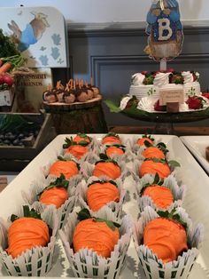 there are many cupcakes in the tray on the table with other desserts