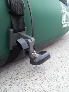 a close up of a luggage strap attached to a green bag with a black handle