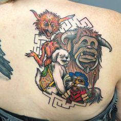 a woman's back with an image of some animals and people on her shoulder