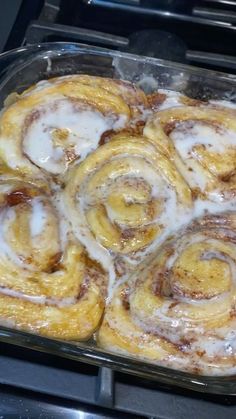 some cinnamon rolls are in a pan on the stove