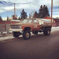 an old truck is parked on the side of the road in front of some houses