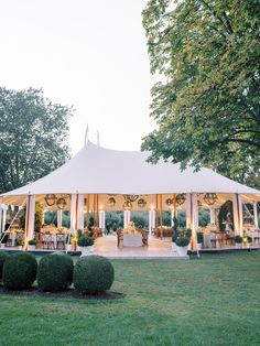 a large white tent sitting on top of a lush green field