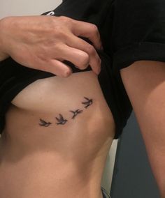 a woman's stomach with birds tattoo on her left side, and the bottom part of her body visible