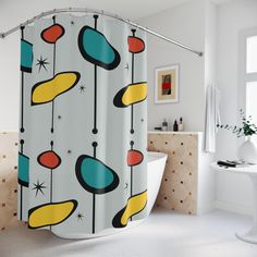 a bathroom with a bathtub, sink and shower curtain that has an abstract design on it