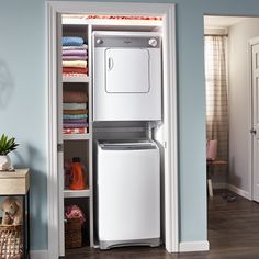 a white refrigerator freezer sitting inside of a kitchen next to a shelf filled with towels