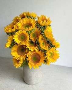 a vase filled with lots of yellow sunflowers