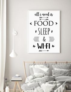 a bed with pillows and blankets in a bedroom next to a painting on the wall that says all i need is food, sleep and wifi