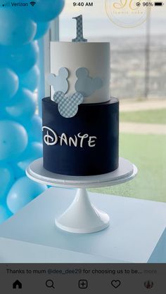 a mickey mouse cake on a table with balloons in the background and an instagram post about it