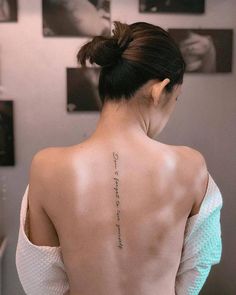 the back of a woman's neck with tattoos on her upper and lower back